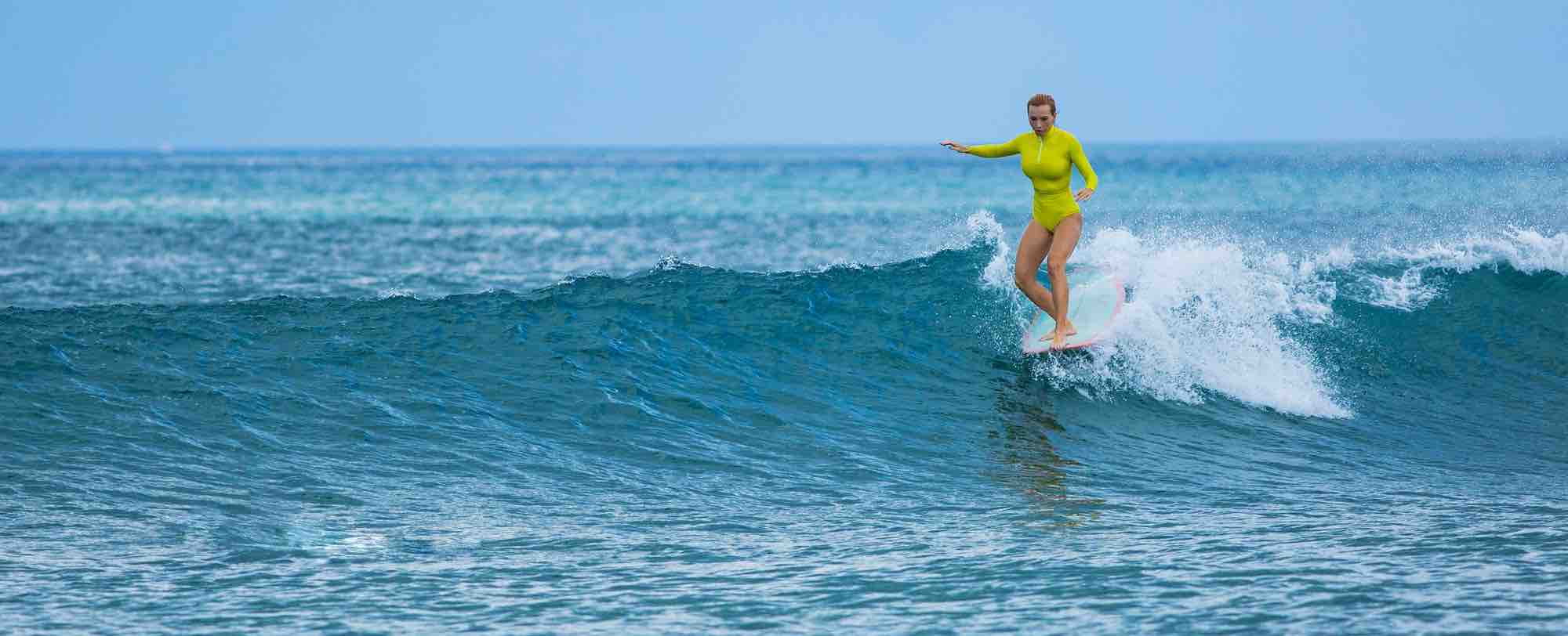 Surfer in Hiriketiya's horseshoe bay before an Udawalawe safari day tour, Sri Lanka