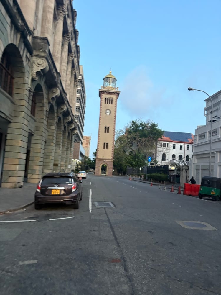 The old lighthouse clock tower at the end of a quiet colonial street in Colombo Fort