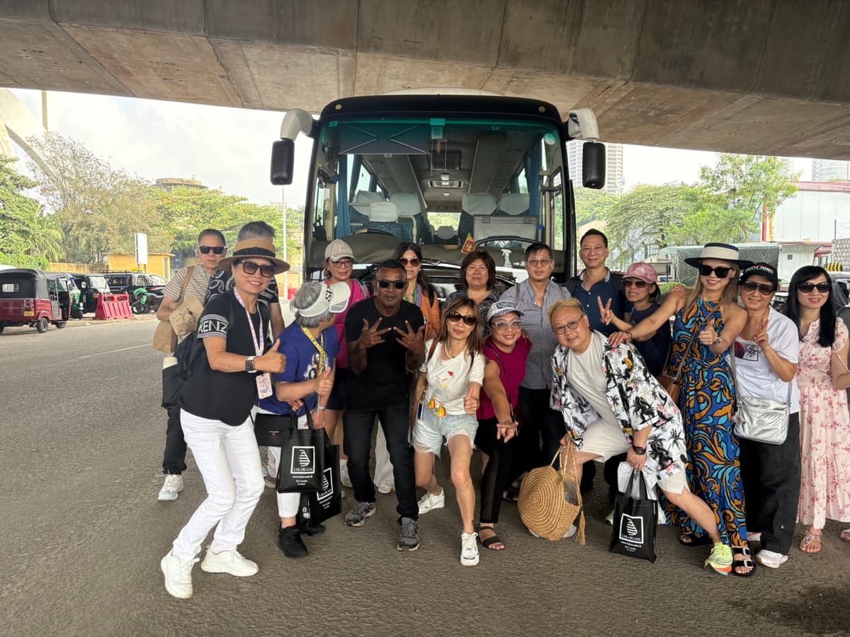 A group of travellers posing with their bags beside a coach before setting off from the city