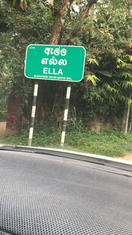 Green road sign reading ELLA in English, Sinhala and Tamil, marking an elevation of 1041 metres