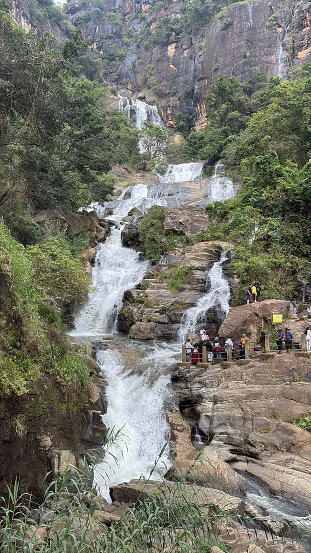 Ravana Falls tumbling down a wide rock face surrounded by dense jungle near Ella