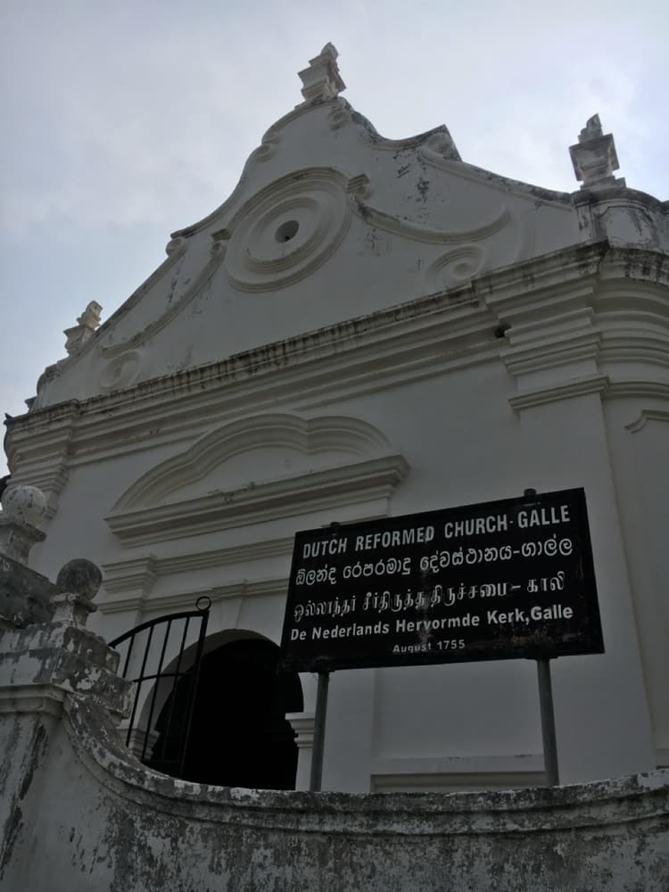 The white gabled facade of the Dutch Reformed Church inside Galle Fort, its name board dated 1755