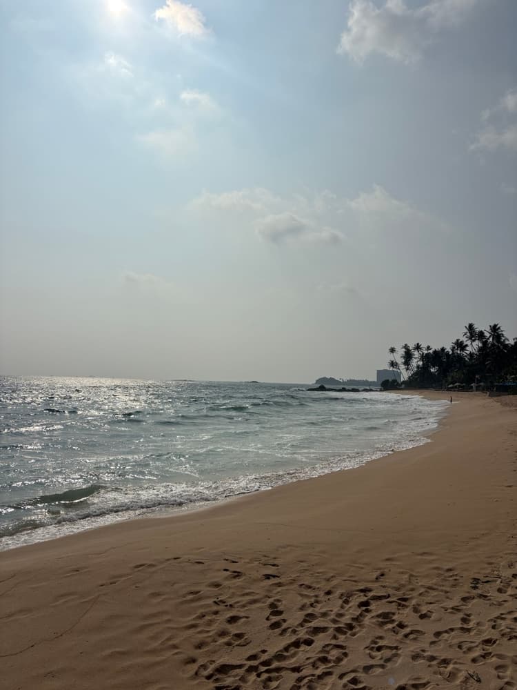 Wide empty beach sweeping towards a distant headland on the south coast near Tangalle