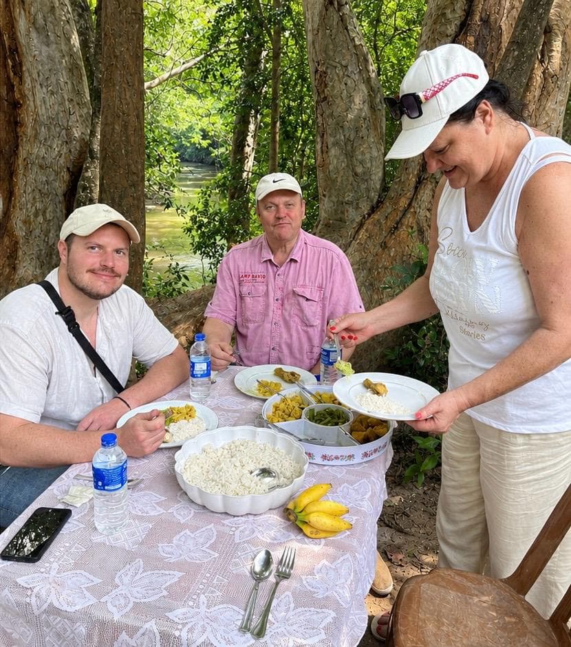 Guests being served a home-style Sri Lankan rice and curry lunch at a picnic table during a full-day safari